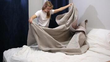 morning routines. young woman wearing pajamas making bed in the morning video