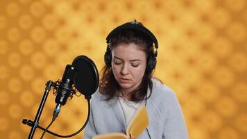 dama hojeada páginas, haciendo narración leyendo de libro a Produce audio libro. voz actor preparando a utilizar cuentacuentos habilidades a entretener audiencia mientras grabación novedoso, estudio fondo, cámara un video