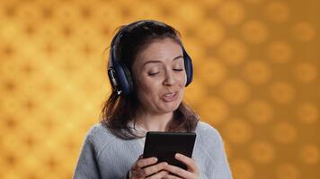 Voice actor smiling while reading ebook, portraying proud and sassy character, studio background. Woman reenacting digital novel, interpreting cheerful protagonist, reading text from tablet, camera A video