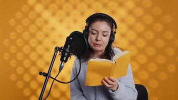 mujer sensación cansado mientras haciendo narración de libro y productor audio libro todas día. narrador sufrimiento dolor de cabeza desde fatiga, haciendo digital grabación de novedoso, aislado terminado estudio fondo, cámara si video