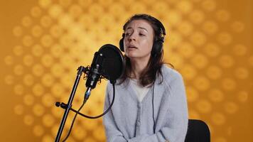 Voice actor reading book, recording for audiobook production using microphone and headset, studio background. Person using mic and headphones to produce digital recording of novel, camera B video