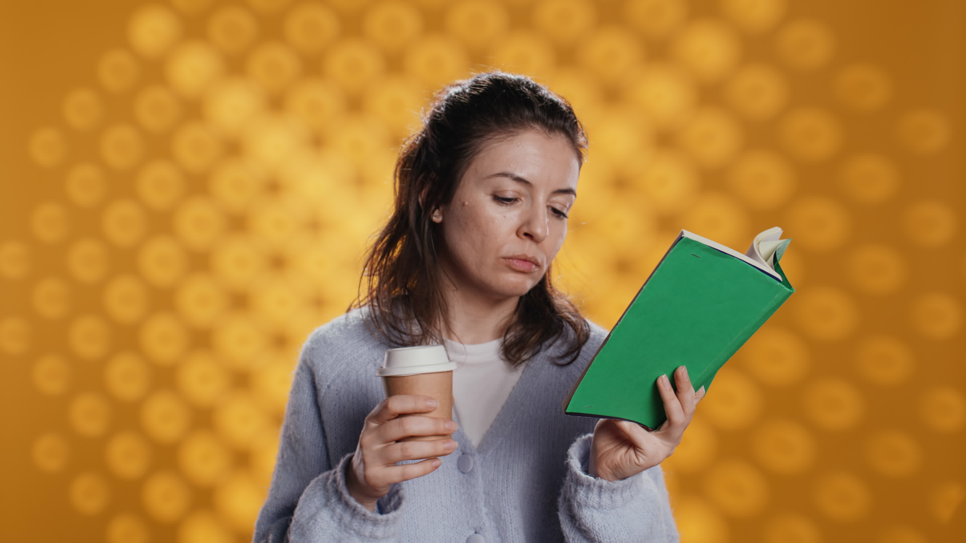 femme en train de lire livre, tournant page et en portant jetable tasse de café, isolé plus de
