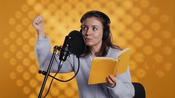 Voice actor looking to producer off camera to know when to start narrating book, producing audiobook. Narrator doing counting on fingers gesturing before starting digital recording of novel, camera B video