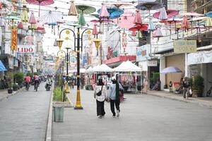 Tasikmalaya, West Java, Indonesia. March 06 2024. -Photo of the atmosphere of visitors with decorative umbrellas in the center of Tasikmalaya city, Cihideung district. It's called PAYUNG GEULIS photo