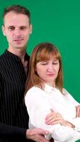 A guy and a girl in black and white clothes, Yin-Yang, talking and smiling on a green background. Vertical , We look at the camera and at each other video