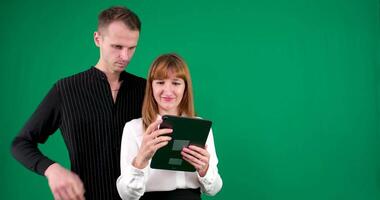 A guy and a girl in black and white clothes, Yin-Yang, talking and smiling on a green background. video