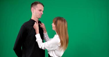 un' tipo e un' ragazza nel nero e bianca Abiti, Yin Yang, parlando e sorridente su un' verde sfondo. noi Guarda a ogni altro video