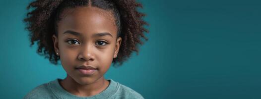 An African American Youngster Girl Isolated On A Teal Background With Copy Space. photo