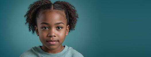 An African American Juvenile Girl Isolated On A Teal Background With Copy Space. photo