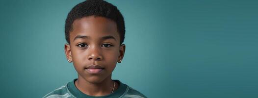 An African American Youthful Boy Isolated On A Teal Background With Copy Space. photo