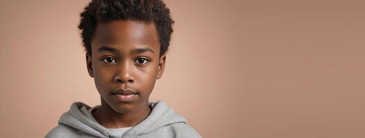 An African American Kin Boy Isolated On A Peach Background With Copy Space. photo