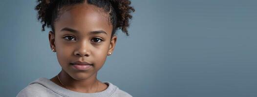 An African American Juvenile Girl Isolated On A GreyBlue Background With Copy Space. photo