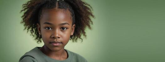 An African American Juvenile Girl Isolated On A Green Background With Copy Space. photo