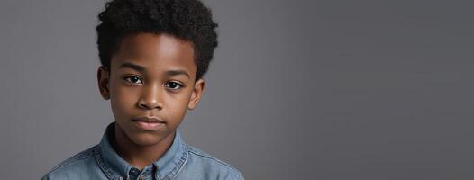 An African American Juvenile Boy Isolated On A Grey Background With Copy Space. photo