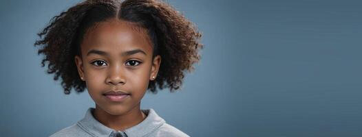 An African American Juvenile Girl Isolated On A GreyBlue Background With Copy Space. photo