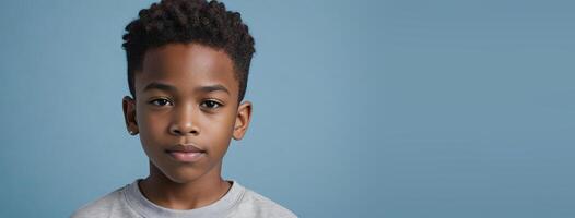 An African American Juvenile Boy Isolated On A Light Blue Background With Copy Space. photo