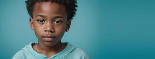 An African American Juvenile Boy Isolated On A Turquoise Background With Copy Space. photo