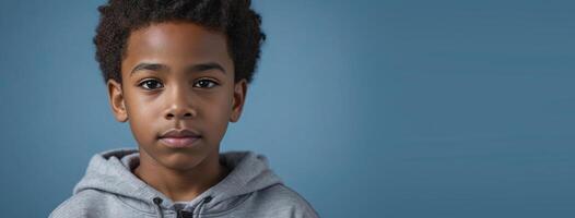 An African American Juvenile Boy Isolated On A Blue Background With Copy Space. photo