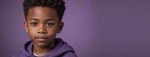 An African American Juvenile Boy Isolated On A Purple Background With Copy Space. photo
