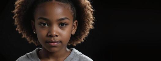 An African American Juvenile Girl Isolated On A Black Background With Copy Space. photo