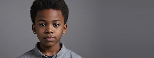 An African American Juvenile Boy Isolated On A Grey Background With Copy Space. photo