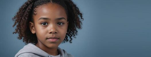 An African American Juvenile Girl Isolated On A GreyBlue Background With Copy Space. photo