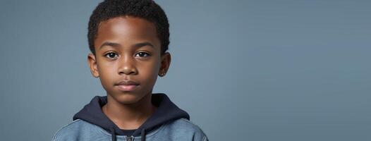 An African American Juvenile Boy Isolated On A GreyBlue Background With Copy Space. photo