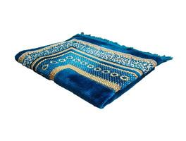 Folded Muslim prayer mat used to pay on white background photo