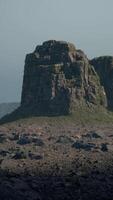 A large rock formation in the middle of a desert video