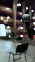 A microphone and a sheet music stand in front of a stage video