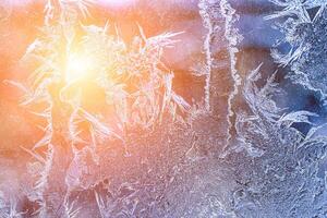 Frost texture on frozen glass illuminated by the sun in winter. photo