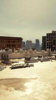 A city skyline with numerous buildings as seen from a rooftop video