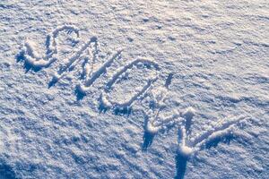 el palabra nieve escrito en el nieve. invierno y frío clima concepto. foto