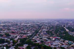 uzbekistán, Tashkent - septiembre 29, 2023 parte superior ver desde el observación cubierta en el Tashkent televisión torre a el central parte de el ciudad cubierto con niebla tóxica a puesta de sol . aire polución. foto