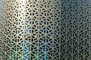 The texture of the cladding of a building made of metal aluminum panels with a carved pattern. Abstract background. photo