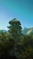 A house in the middle of a forest with mountains in the background video