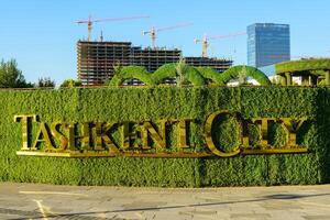 Uzbekistan, Tashkent - September 27, 2023 The logo of the Tashkent city park lit by sun on a green grass background. photo