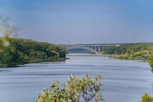 Distant River Bridge Framed by Foliage photo