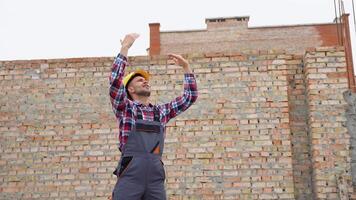 sérieux directeur dans casque et uniforme donnant commandes à grue opérateur. barbu homme faire des gestes et en criant pendant travail processus video