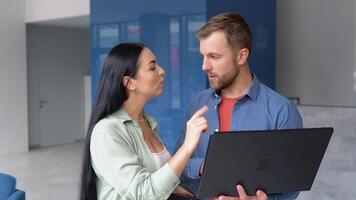 Motivated diverse colleagues look at laptop screen discuss business project ideas together video