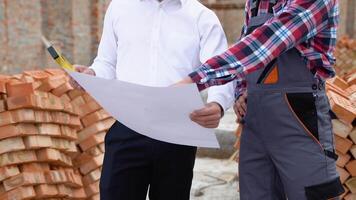 Two engineers working in a construction site, close up video