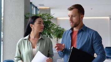 Confident business partners walking in office building and talking video