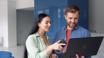 concentrado masculino empresario mirando a computadora monitor, trabajando con un joven hembra trabajador en un proyecto, personas participación un reunión con un cliente o entrevistando un trabajo candidato video