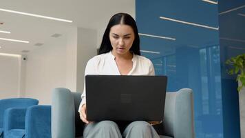 Confident and cheerful caucasian brunette woman opening and typing on a laptop video