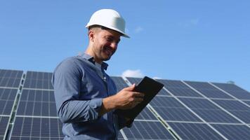 Engineer solar photovoltaic panels station checks with tablet computer video