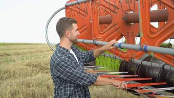 een boer inspecteert de combineren voordat werk video