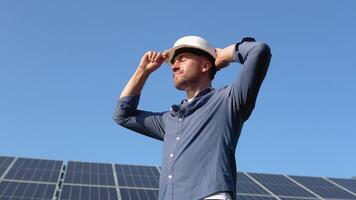 Solar power plant. Man standing near solar panels. Renewable energy video