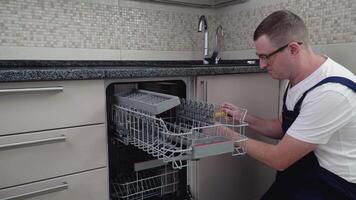reparador reparando lavavajillas en cocina. reparar de Lavaplatos video