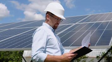 Engineers checking solar panels with tablet. Alternative energy ecological concept video