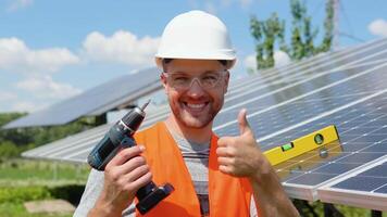Portrait of confident engineer with screwdriver of solar cell farm industry. Staff confident pose Solar cell panel installation video